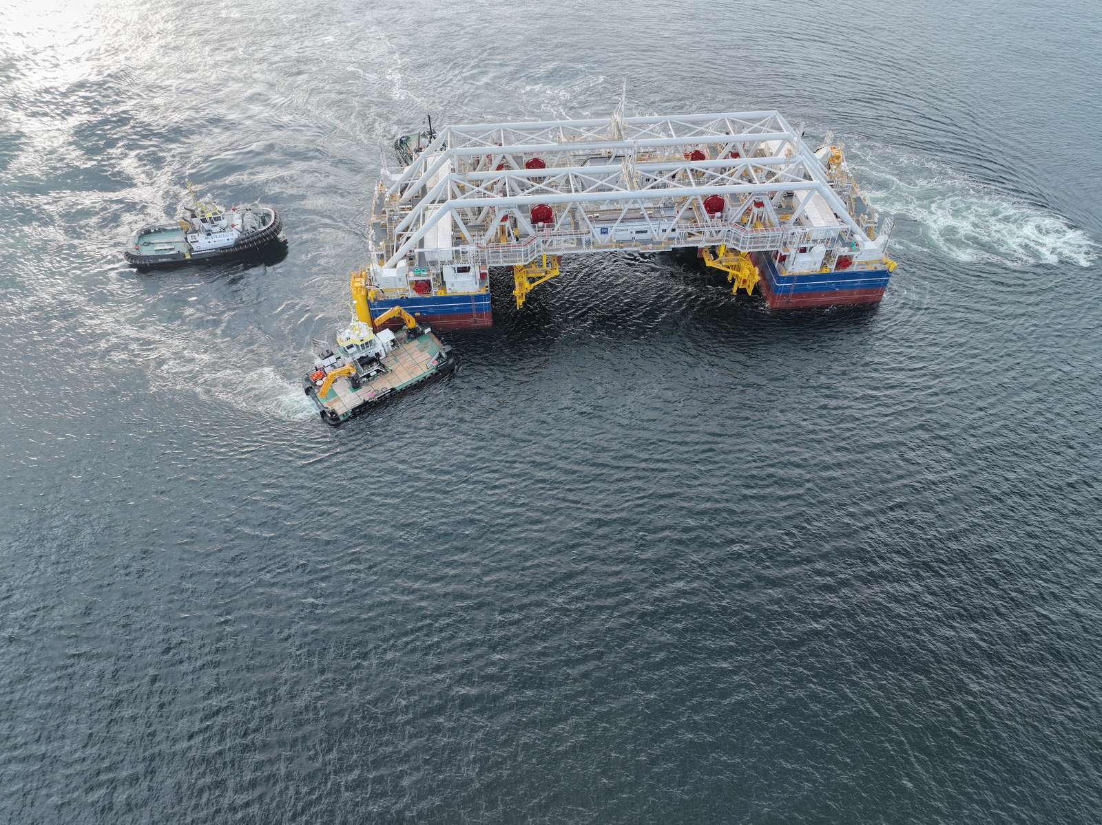 Special vessel IVY. It consists of two parts, both of which resemble a large clamp. The pontoon sections that hold the tunnel elements are connected by a large white lattice structure.