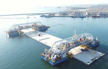 The immersion pontoons IVY 1 and IVY 2 each hold a standard element at their respective end. The element and the two immersion pontoons are floating in the work harbour.