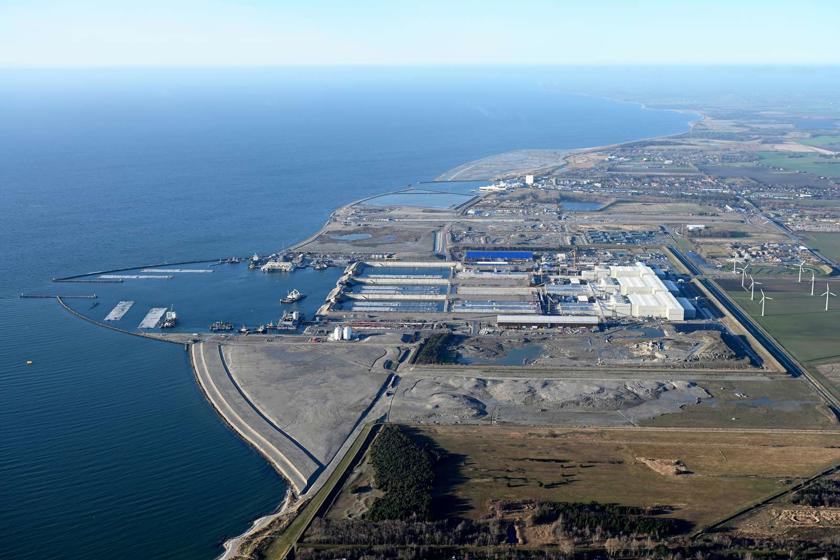 Blick über die gesamte dänische Tunnelbaustelle an der Küste Lollands. In der Bildmitte liegt die Tunnelfabrik mit ihren großen weißen Hallen.