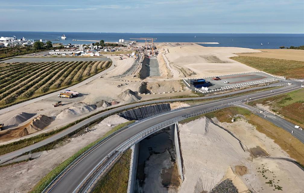 Drohnenfoto in Richtung Norden: In der Bildmitte ist die Bahntrasse zur Tunneleinfahrt zu sehen, die von einer neuen Brücke überquert wird. Dahinter sind Arbeiten am Bahntrog erkennbar.