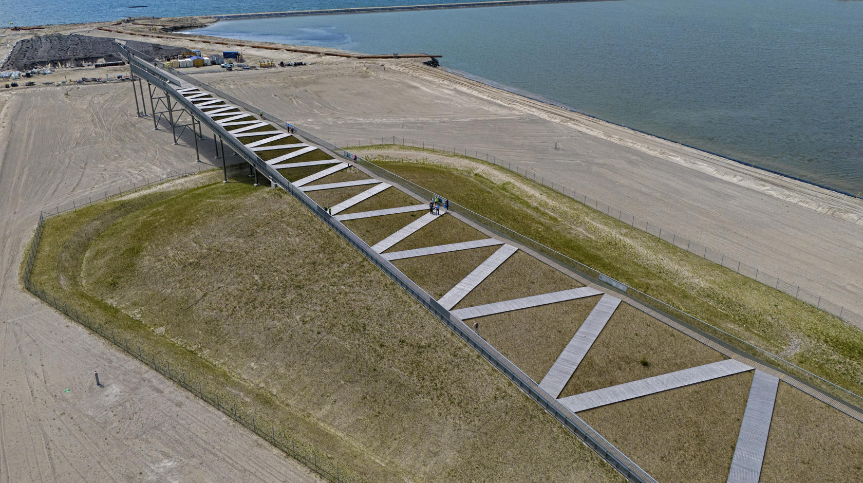 View from above of the Pilen viewing platform. A ramp that tapers to a point with a zigzag path leading upwards.