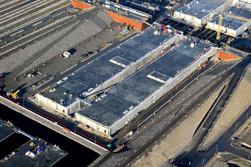 Zwei fertig betonierte Elemente liegen vor den Fabrikhallen der Tunnelfabrik. Rie Röhren sind mit Schotten wasserdicht verschlossen.