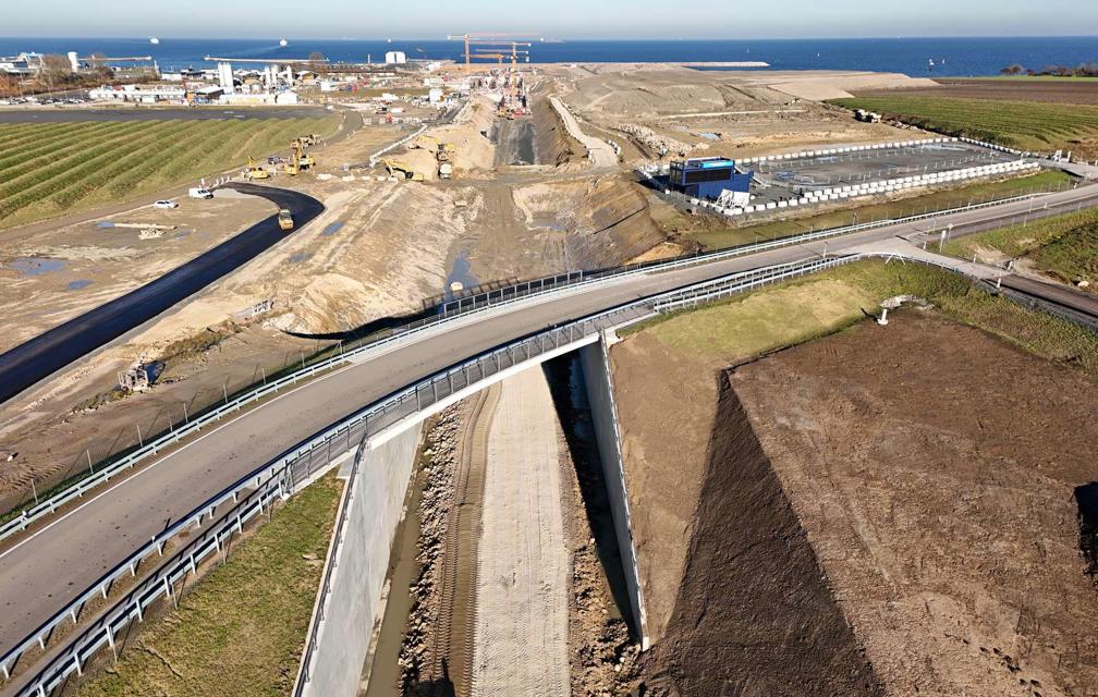 Die Brücke für den neuen Marienleuchter Weg. Eine Straße führt über die Brücke. Unter der Brücke ist die neue Bahntrasse ausgehoben. Sie besteht noch aus Erde und Schotter.